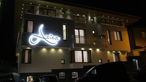 Un hôtel doté d’une enseigne lumineuse bien visible, de nombreux balcons et d’une architecture moderne.