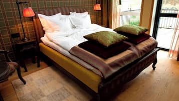 A bed with pillows, a bedside table, a chair, and a window with a view.