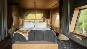 A bedroom with a large bed, a wooden headboard, a window with a view of trees, and a stone wall.