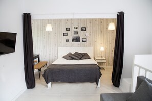 A bedroom with a bed, bedside tables, a desk, and a chair. - Apartamentos Porto Center (Porto)