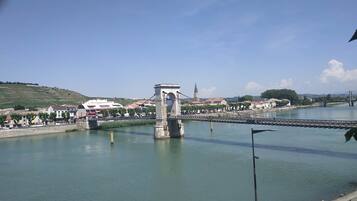 A bridge over a river with buildings and a church in the background.