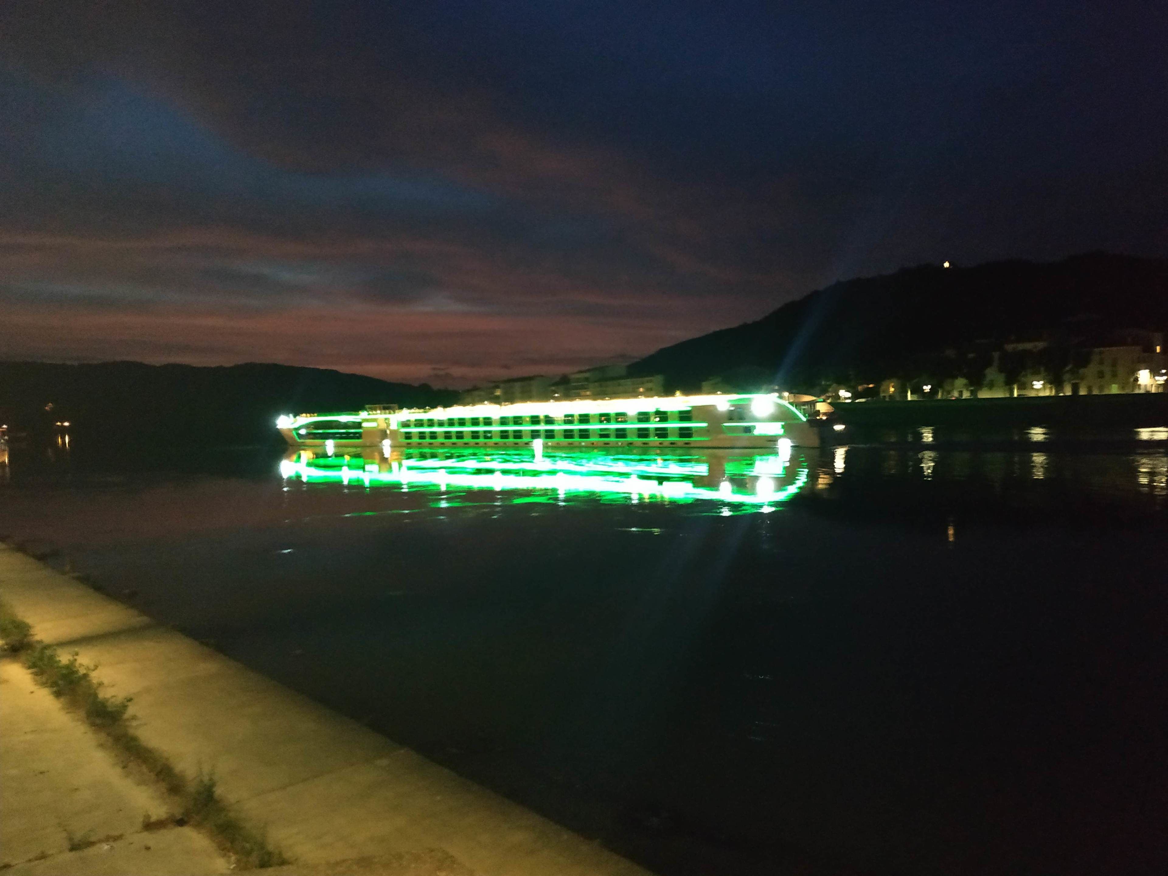 A river with a brightly lit boat.