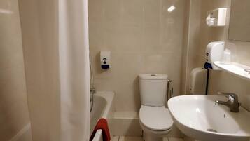 Un baño con bañera, inodoro y lavamanos.
