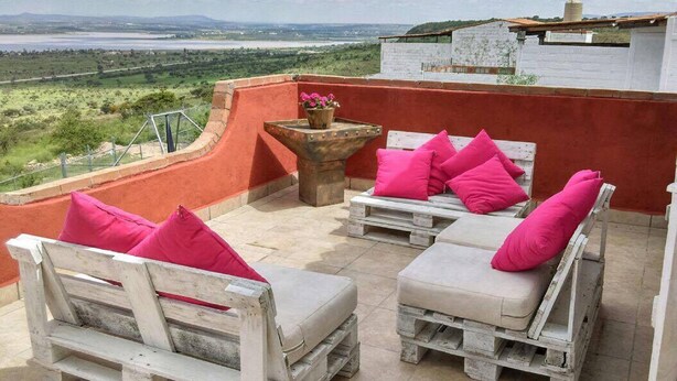 Terraço no telhado com área de estar ao ar livre e vista para um rio.