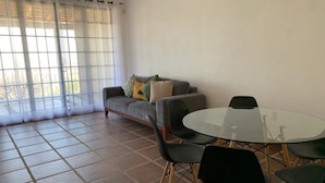 A living room with a sofa, a glass table, and chairs. - Casa Tulipan (San Miguel de Allende)
