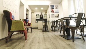 A modern interior with a dining area featuring a wooden floor, metal chairs, and a table. - Cinque Sogni (Rome)