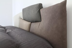 Ein Bett mit einer gesteppten Decke und zwei Kissen.