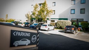 A parking area with a sign indicating the direction to the parking. - B&B HOTEL La Rochelle Centre (La Rochelle)