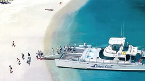 Um barco atracado em uma praia, com pessoas embarcando e desembarcando.