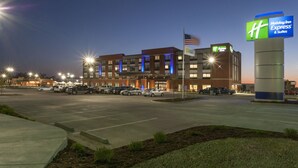 Edificio de Holiday Inn Express & Suites con un estacionamiento al frente.