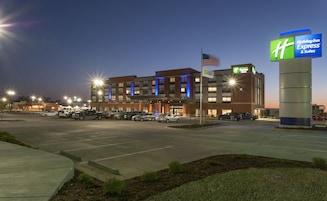 Edificio de Holiday Inn Express & Suites con un estacionamiento al frente.