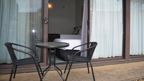 A room with a bed, a small table, and two chairs. - The Apple Inn (Batlow)