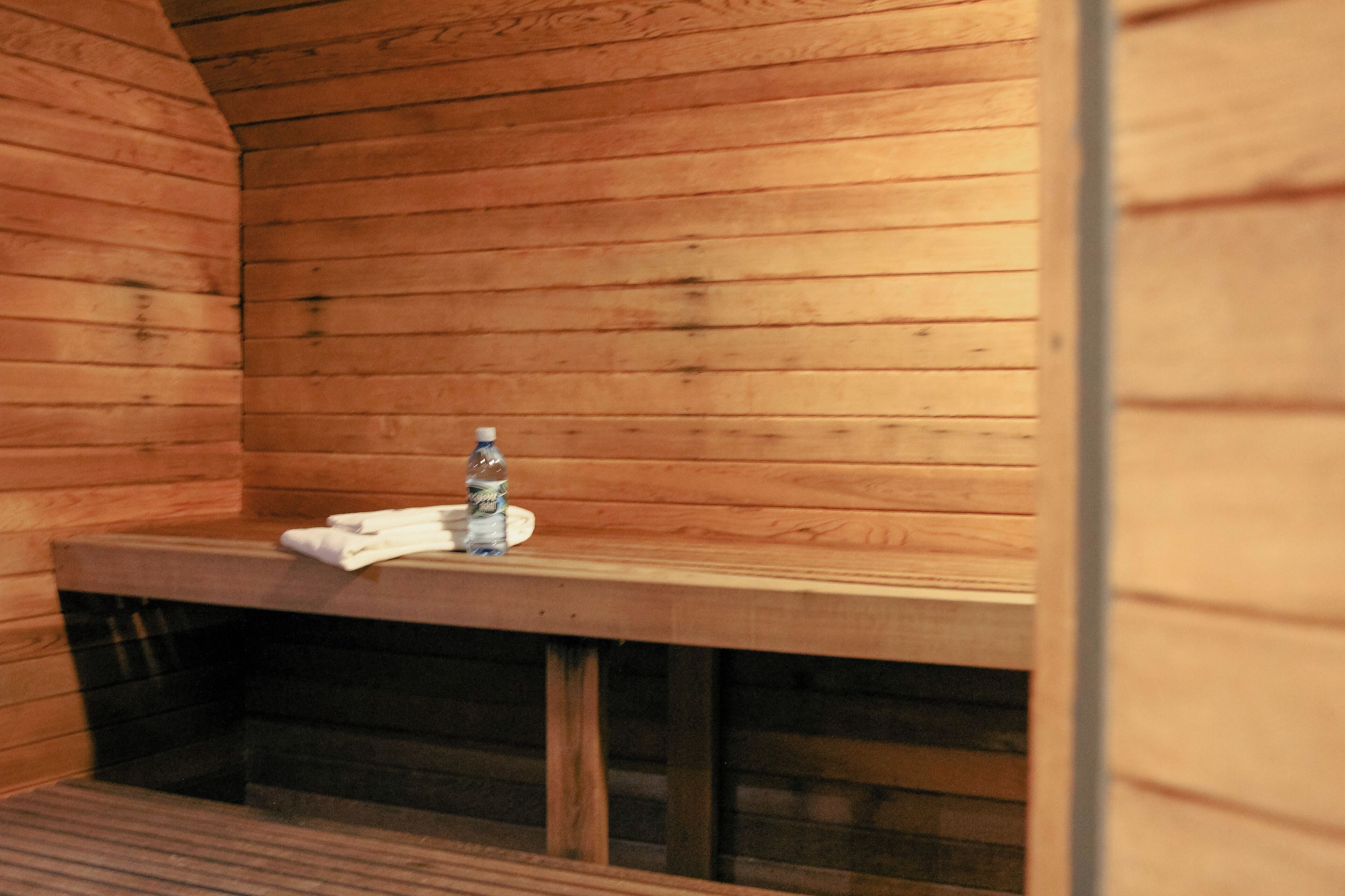 A sauna with wooden walls and a bench.