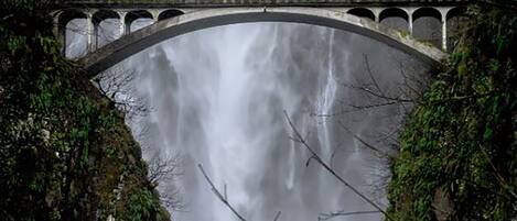 Un puente de piedra con una cascada debajo.