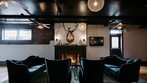 A room with a fireplace, a mounted deer head, and two sofas facing the fireplace. - Hood River Hotel (Hood River)