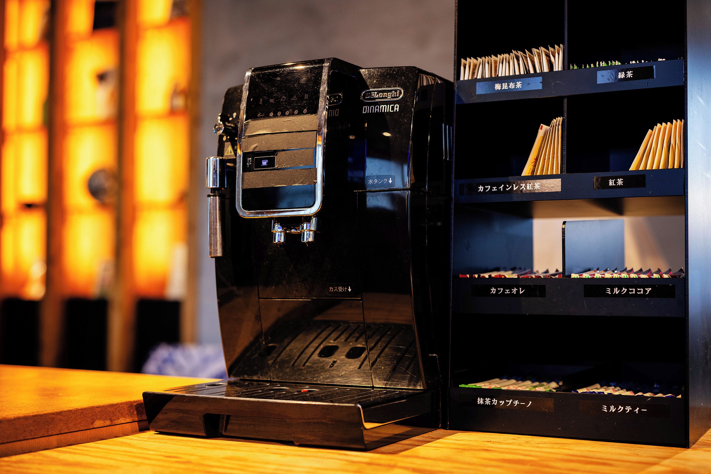 A coffee machine with a digital display and a coffee bean storage area with labeled compartments.