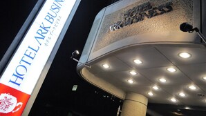 Une enseigne d’hôtel indiquant « HOTEL ARK BUSINESS » et la façade d’un immeuble portant les inscriptions « HOTEL ARK BUSINESS » et « ARK BUSINESS ».