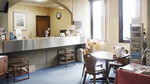 Un espace d’accueil comprenant un comptoir, des chaises, une table et un distributeur automatique.