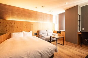 A hotel room with a large bed, a seating area with a chair and a small table, and a desk with a computer. - ArC LIFESTYLE SPACE & HOTEL (Mito)
