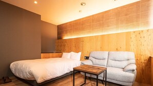 Une chambre à coucher avec un lit, un canapé et une petite table.