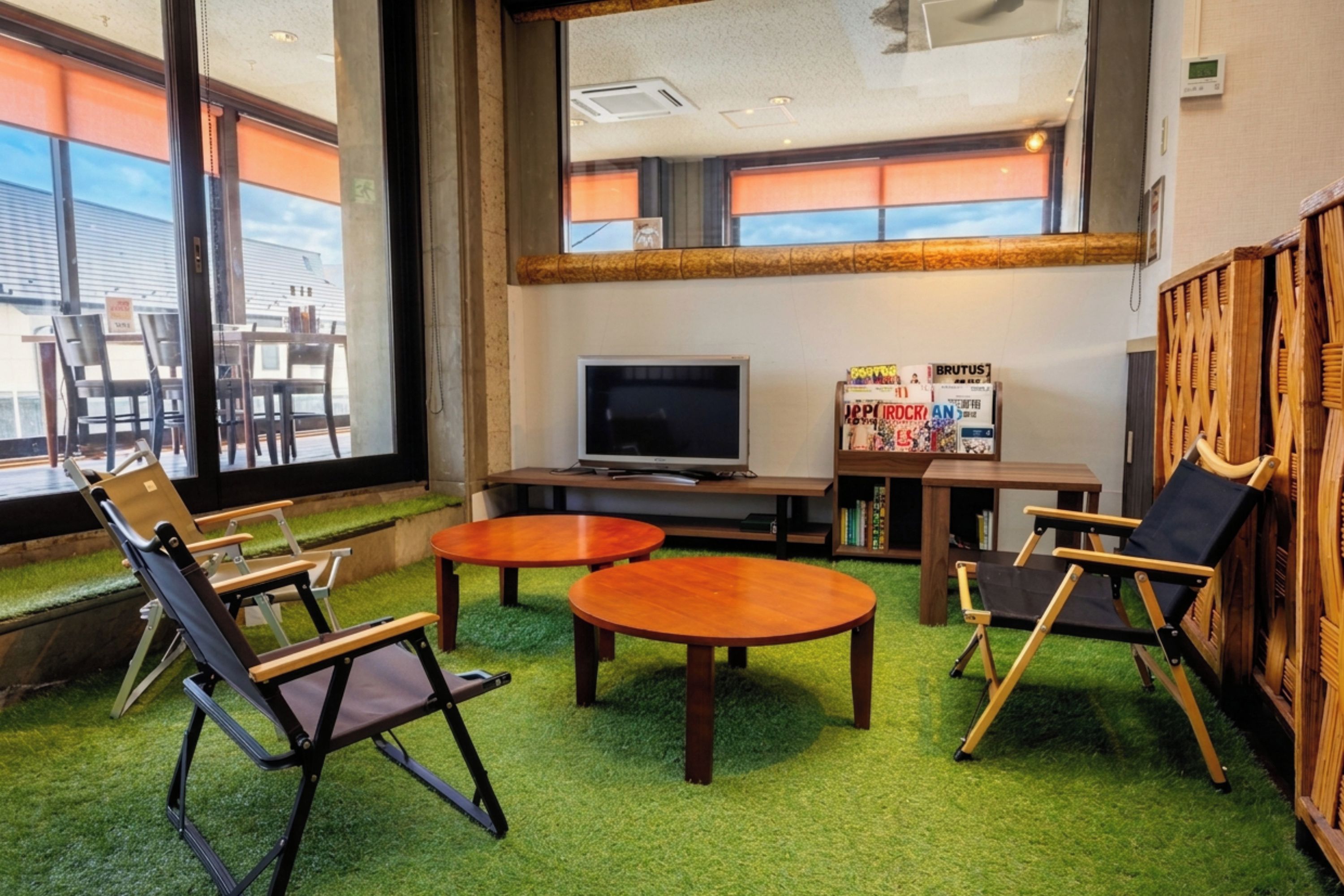 A room with a television, two round tables, and three chairs.