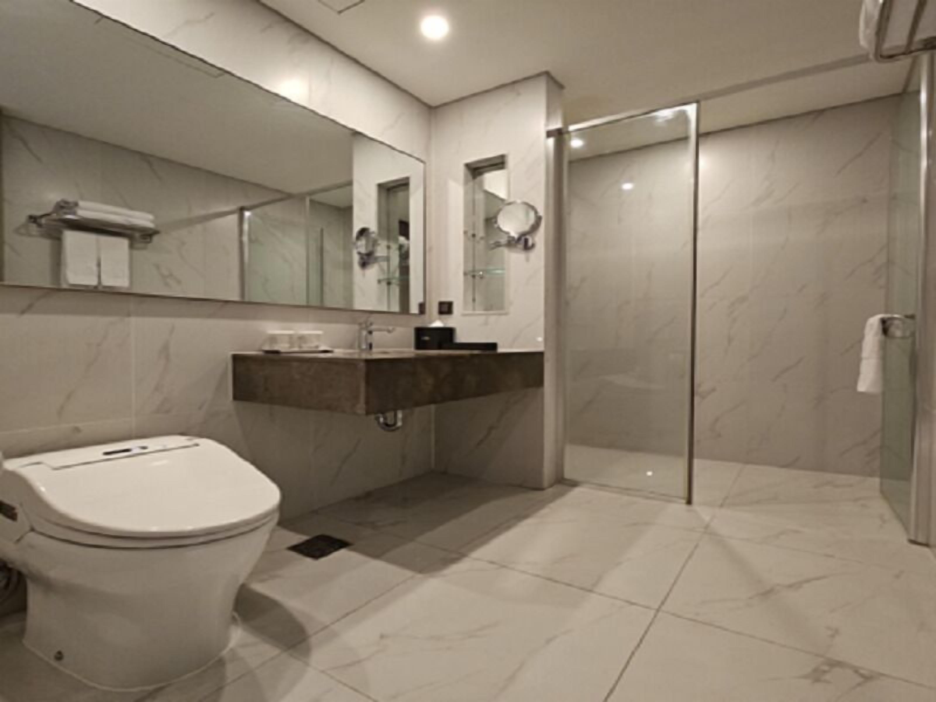 A modern bathroom with a toilet, sink, and shower.
