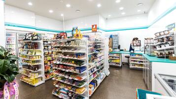 A well-lit convenience store with shelves stocked with snacks, beverages, and household items.