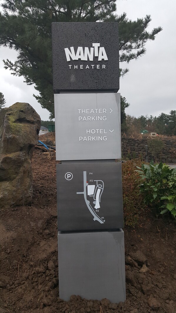 A sign for NANTA Theater with directions to Theater Parking and Hotel Parking. - Hotel Nanta Jeju (Jeju City)