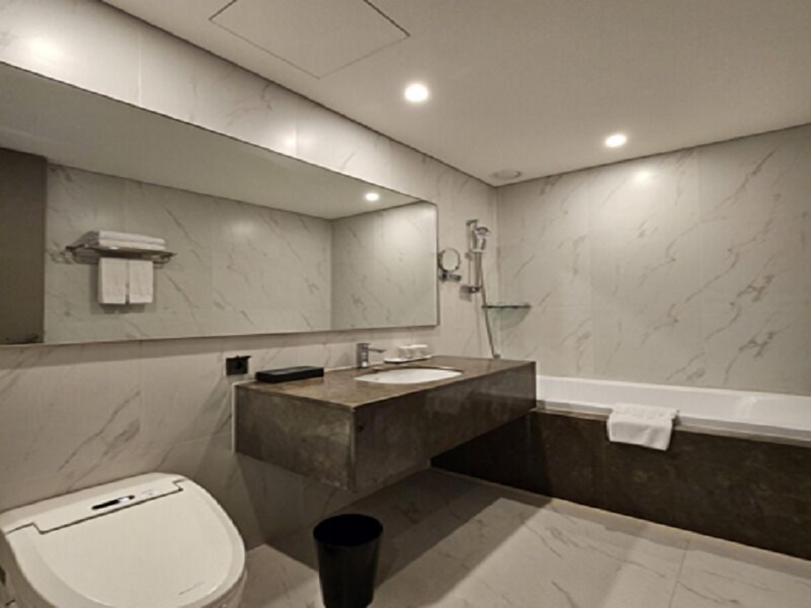 Une salle de bain moderne équipée de toilettes, d’un lavabo et d’une baignoire.