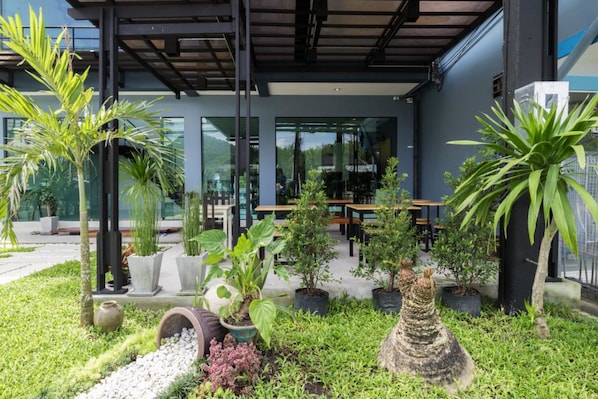 An outdoor seating area with potted plants and a modern building facade.