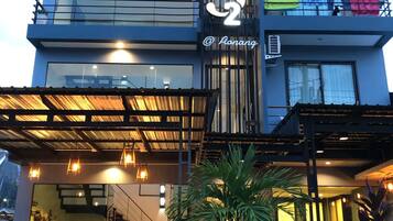 Un hotel moderno con un llamativo logo 'S', un vestíbulo cubierto y una escalera que conduce a los pisos superiores.