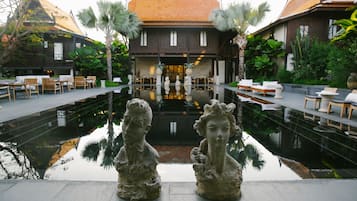 A courtyard with a reflective pool, stone sculptures, and seating areas.