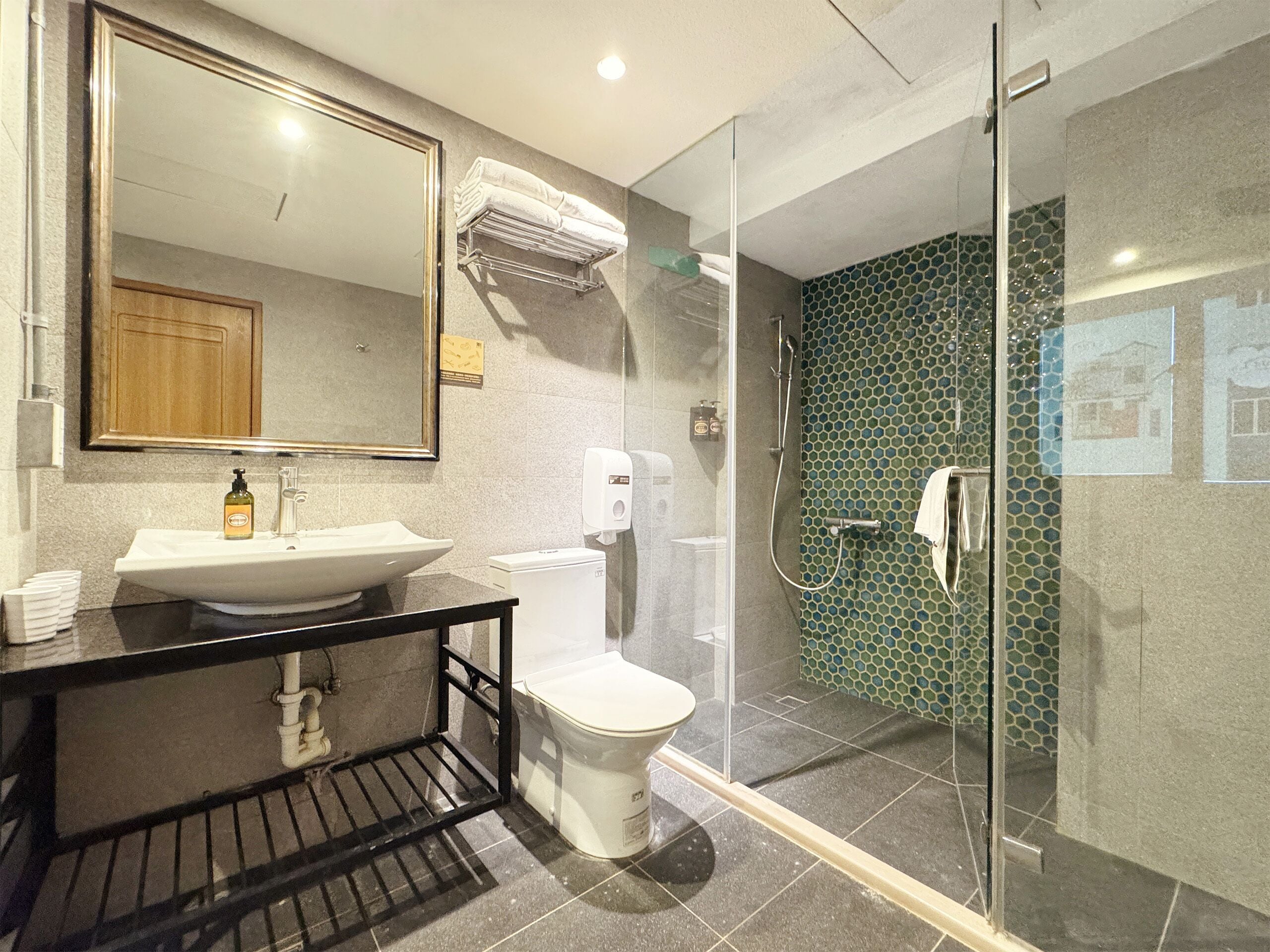 Un baño moderno con lavamanos, inodoro y ducha envuelta en vidrio.
