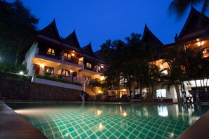 A hotel with a pool, multiple balconies, and a tropical setting. - Kata Interhouse Resort by Haii Collection  (Karon)