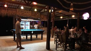 An outdoor bar area with a pool table, wooden tables, and chairs. - Cottage Hill at Lanta (Ko Lanta)