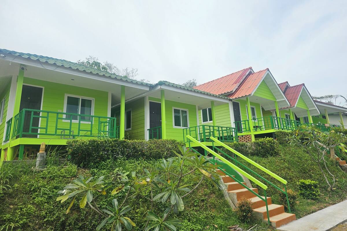 Uma fileira de casas de campo com telhados verdes e uma escadaria que leva à entrada.