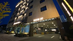 Un hotel a più piani con un cartello che indica 'PARKING LOT', segnalando la presenza di un'area di parcheggio.