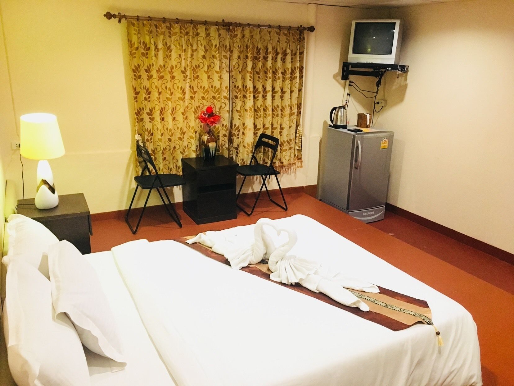 Une chambre d’hôtel comprenant un lit, un bureau avec une chaise, une télévision et un minibar.