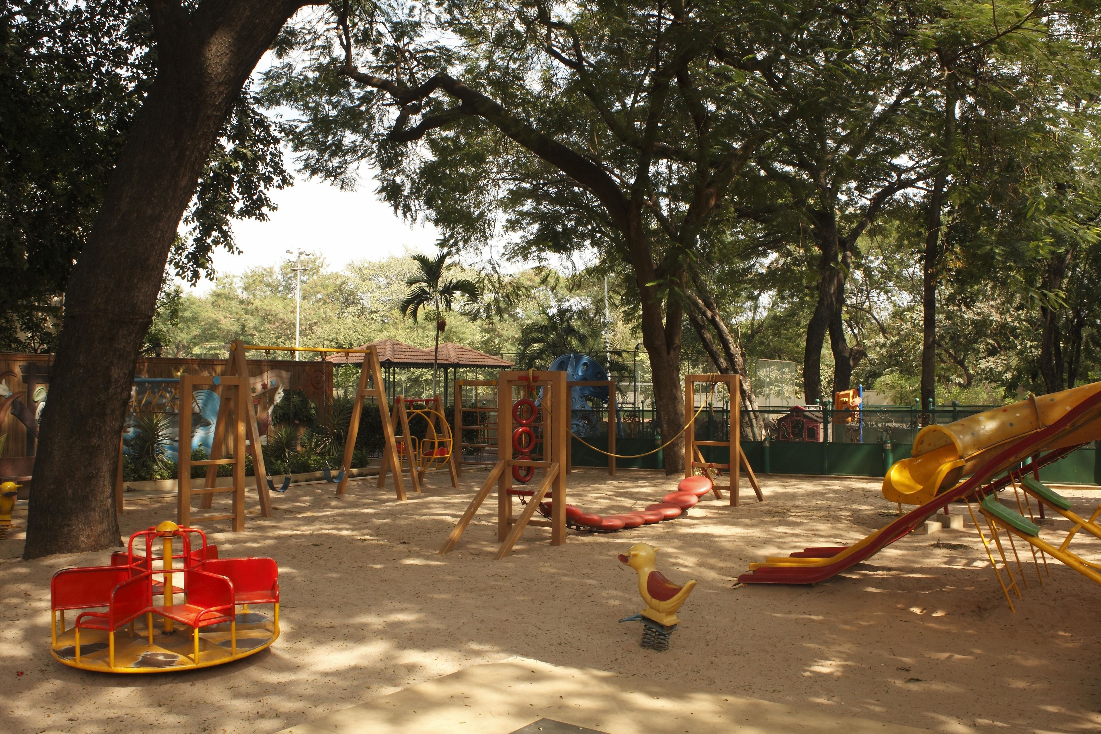 A playground with a slide, swings, and a merry-go-round.