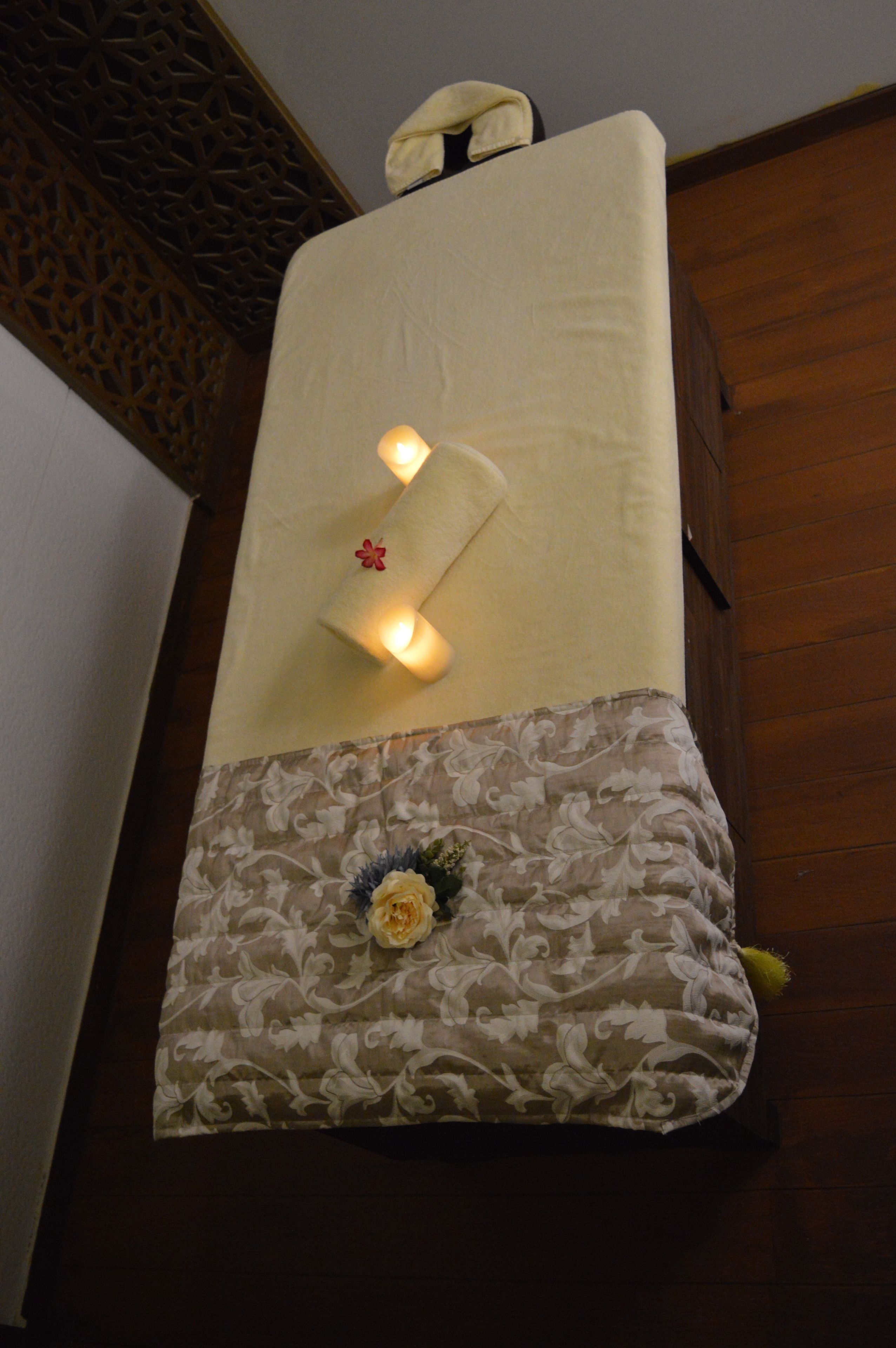 A bed with a floral-patterned pillow and a decorative headboard.