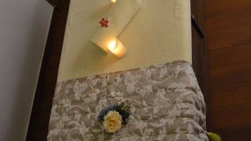 A bed with a floral-patterned pillow and a decorative headboard.