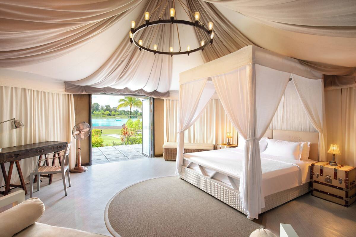 Une chambre spacieuse avec un grand lit, un bureau et une vue sur l’extérieur.