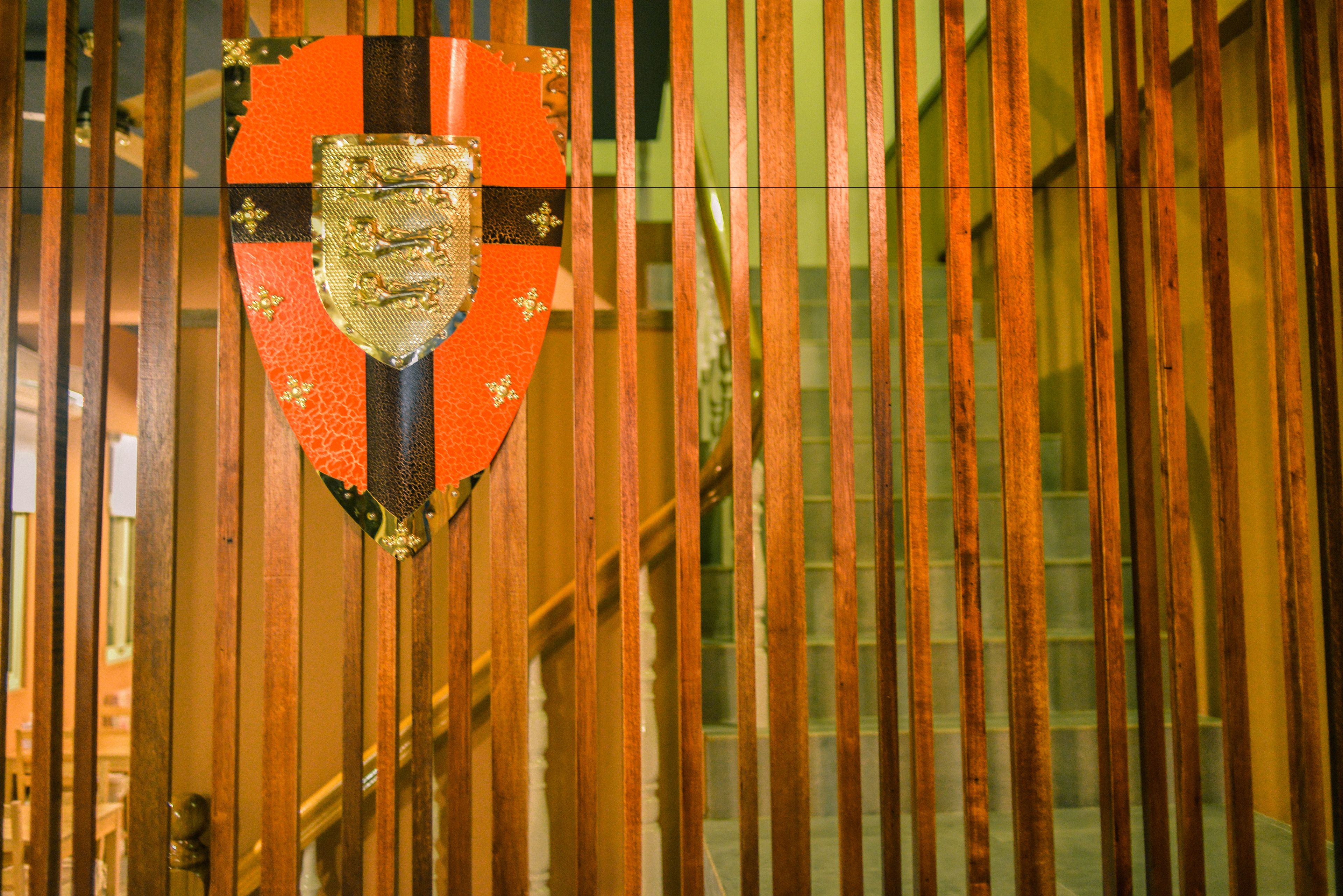 A shield-shaped emblem with a central design, mounted on a pole.
