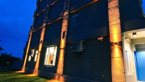 A multi-story building with illuminated exterior lighting, a flat roof, and a visible entrance. - Minsuku (Taitung)