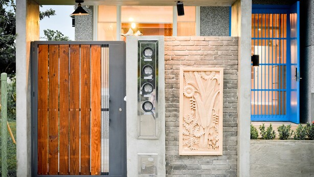 A modern building with a wooden gate, a security panel, and a blue door. - Minsuku (Taitung)