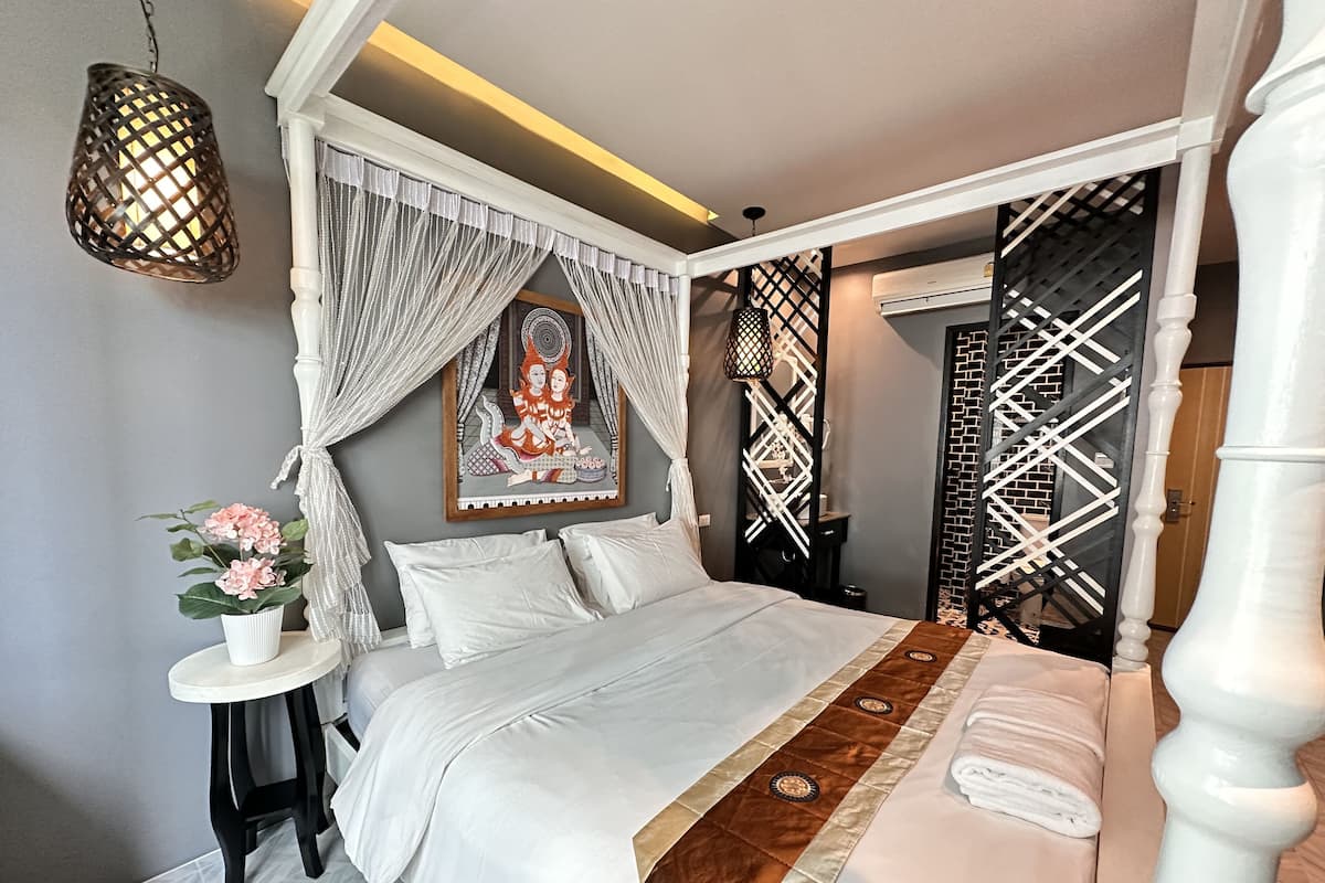 Un dormitorio ordenado con cama, mesita de noche y un adorno en la pared.