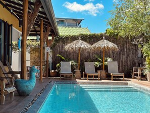 A pool area with lounge chairs and a decorative sculpture. - The Luna Hostel (Sa Khu)
