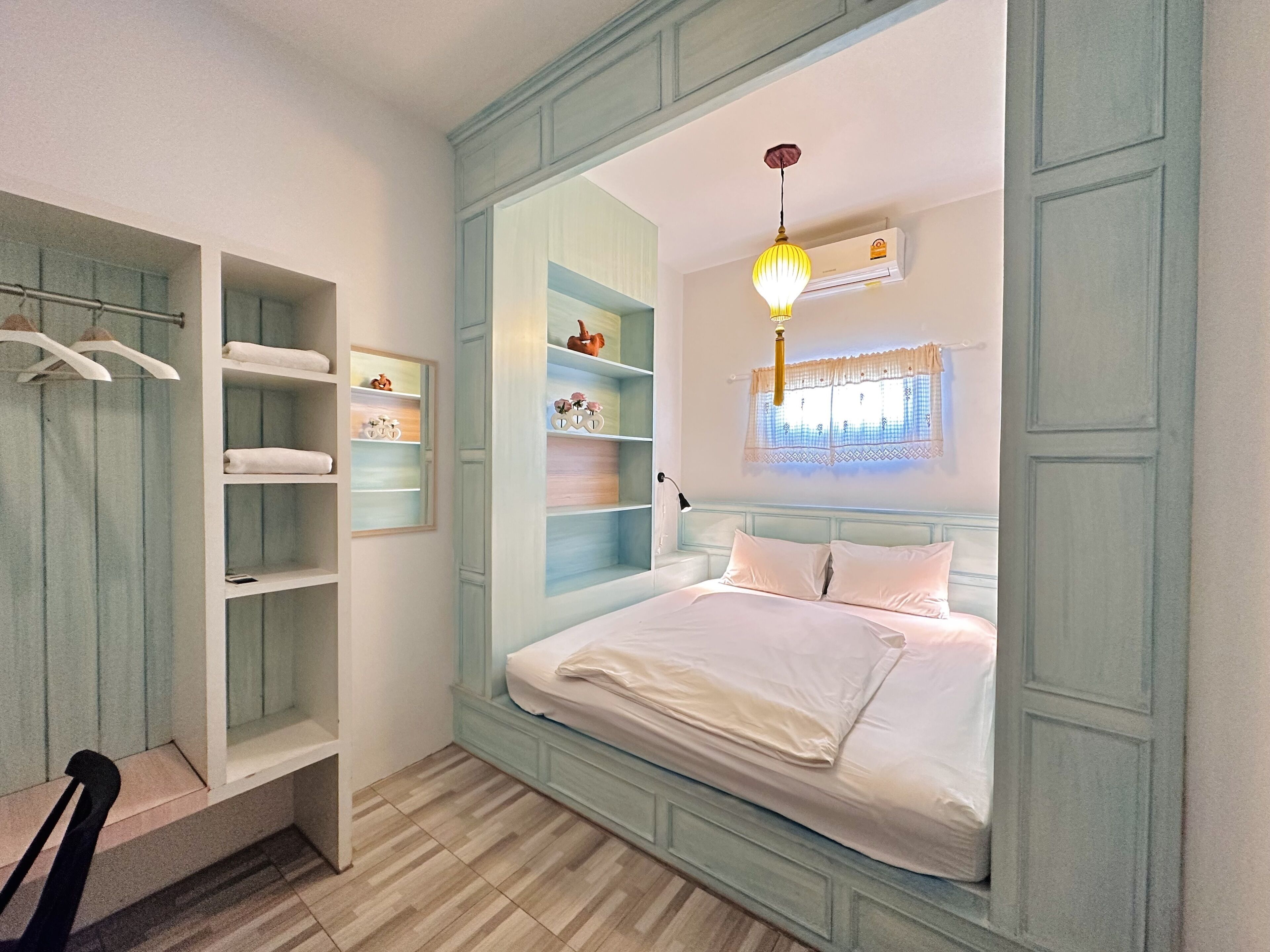 Un dormitorio con cama, armario empotrado y estanterías.