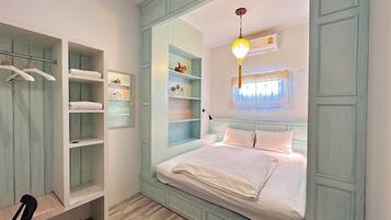 Un dormitorio con cama, armario empotrado y estanterías.