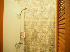A shower with a handheld showerhead and a wall-mounted faucet.